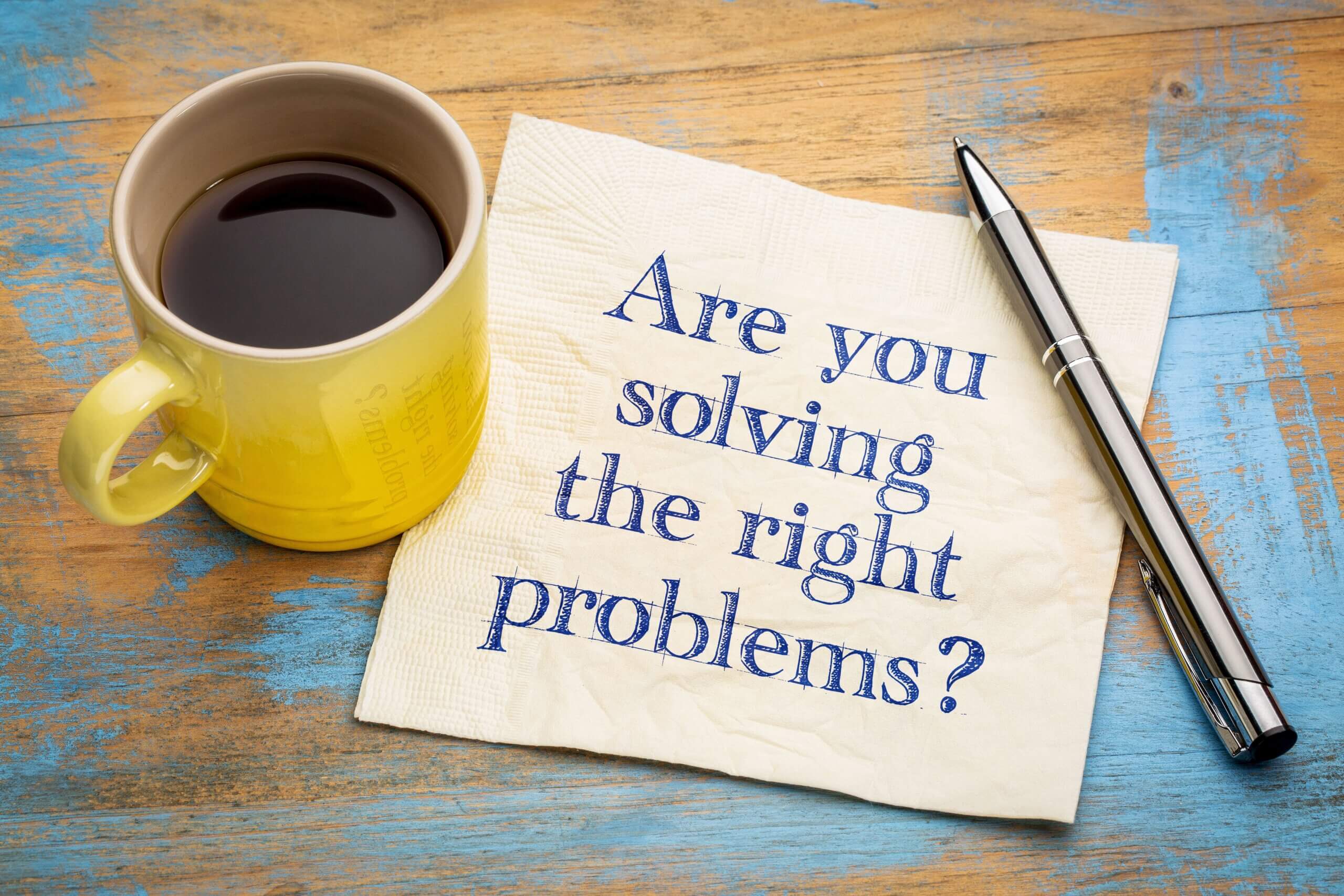 Are you solving the right problems? Handwriting on a napkin with a cup of espresso coffee